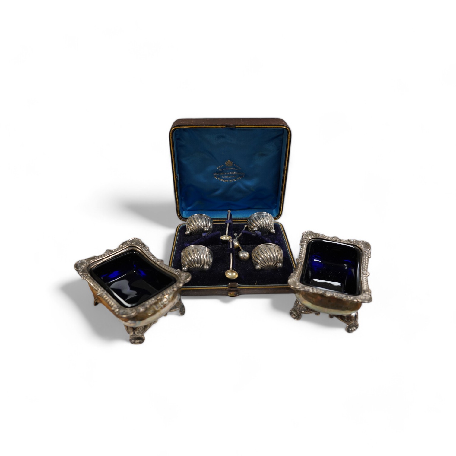 A pair of late Victorian silver rectangular salts, Hawksworth, Eyre & Co, London, 1897, 91mm with blue glass liners and a cased set of four Victorian silver tub salts with spoons. Condition - fair